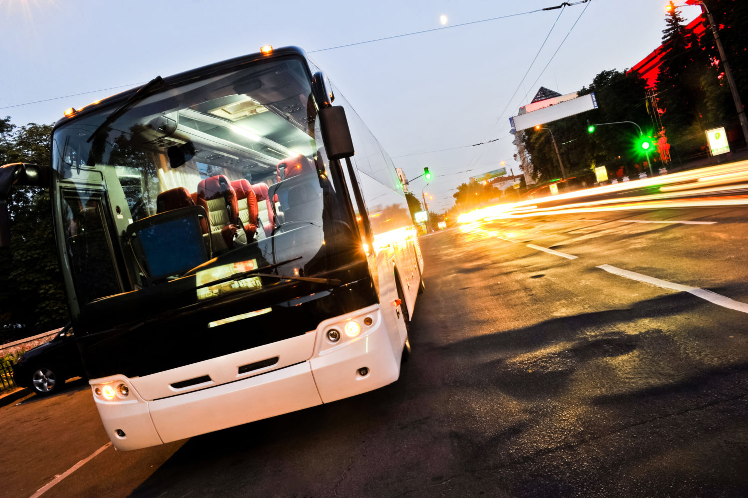 White bus stopped in city traffic while going from Prague to Budapest