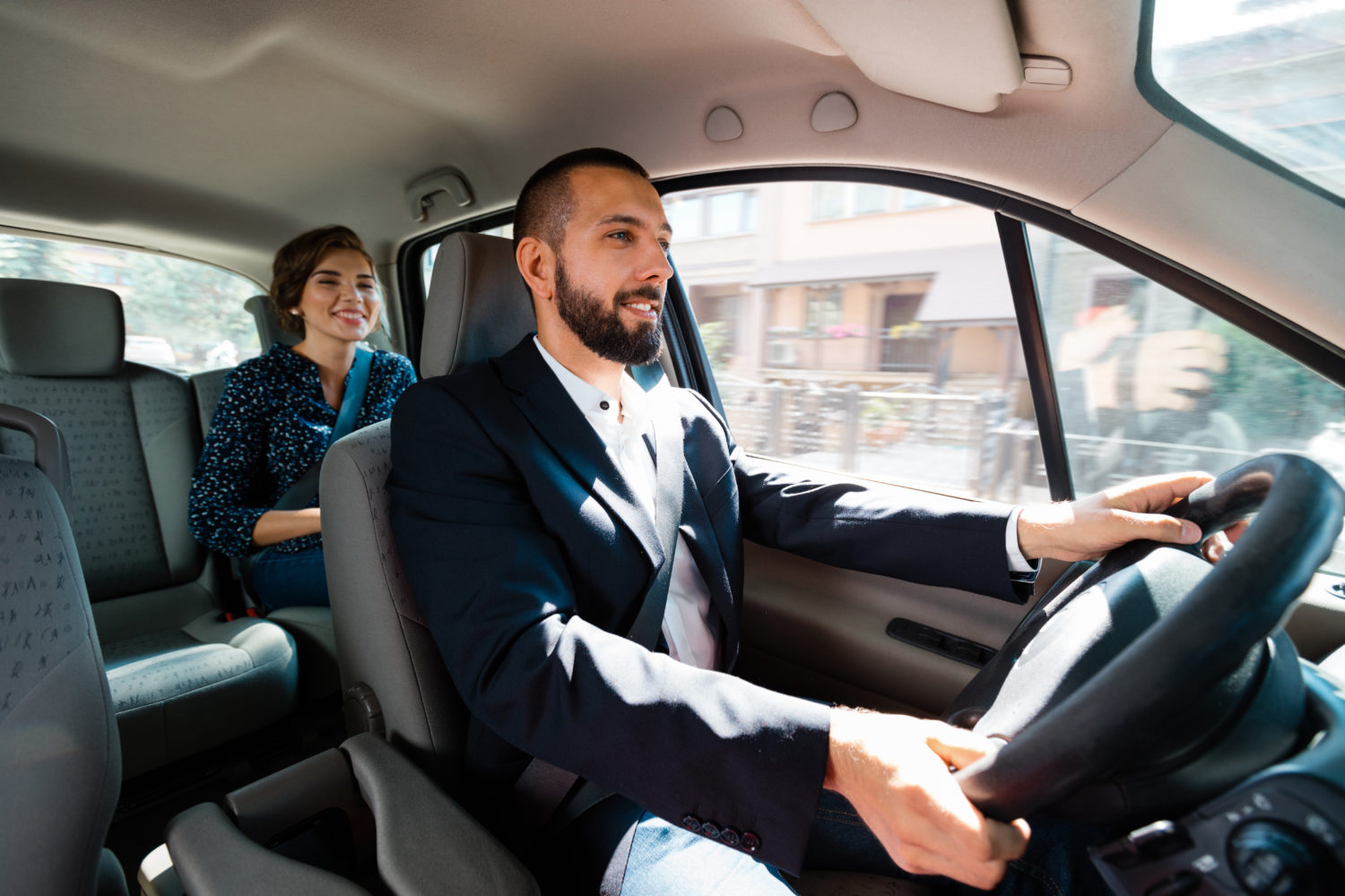 Young woman being driven by a man in a suit from Prague to Dresden