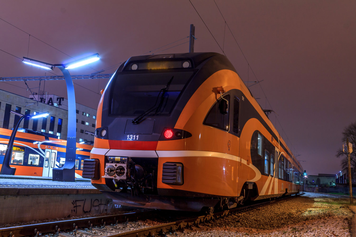 Orange train waiting in train station to go from Tallinn to Riga