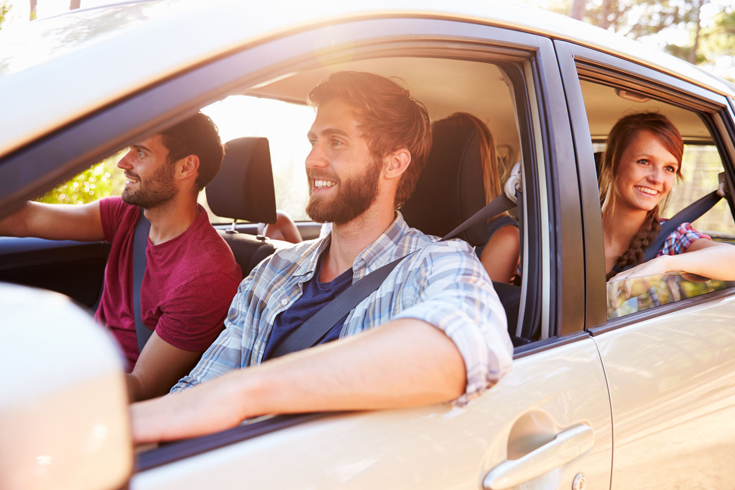 Four young people in a car sharing a ride