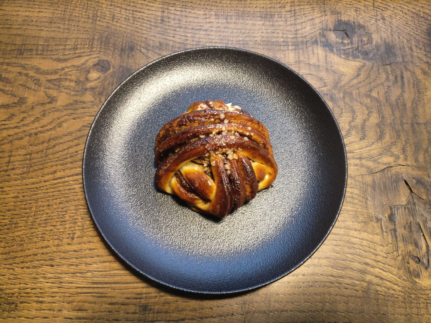 Cinnamon bun on a black plate