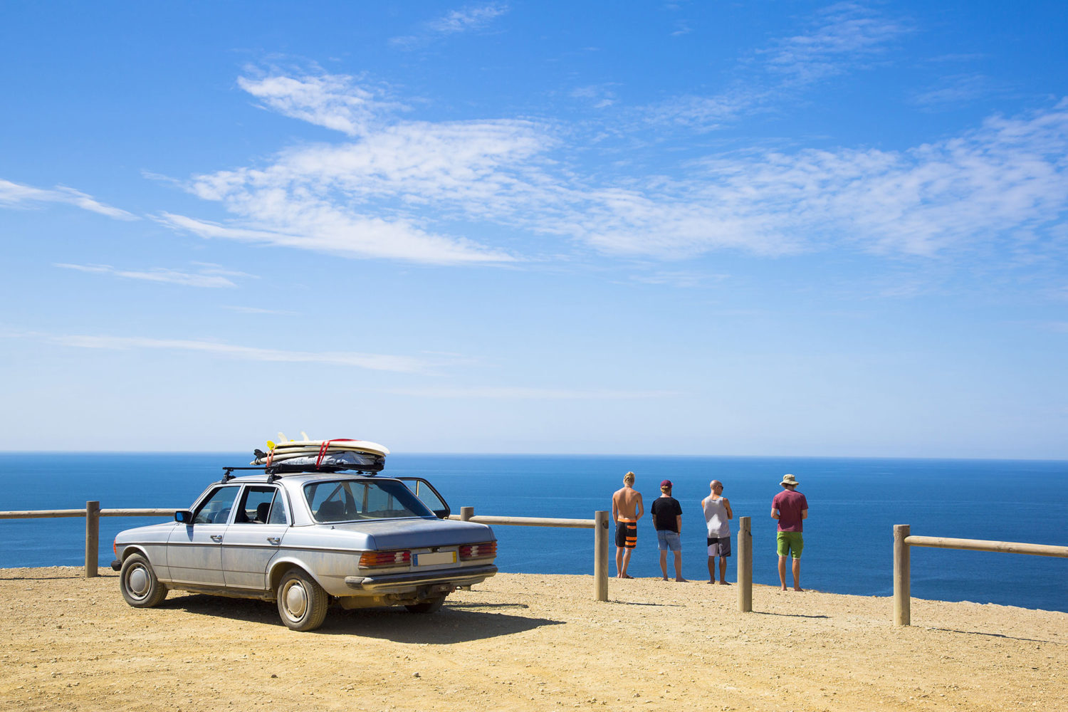 Four men looking at the sea while on a roadtrip in Portugal